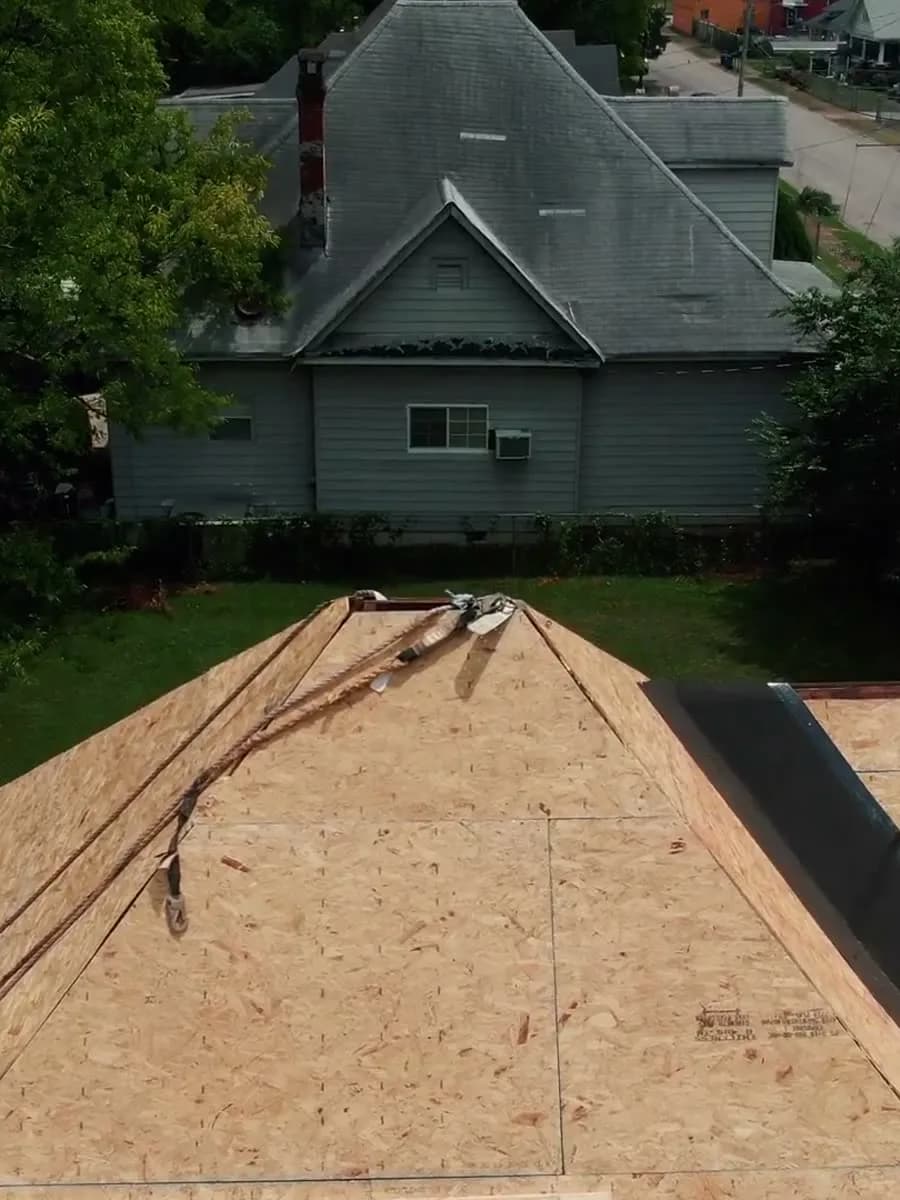 A roof stripped to fresh sheathing during a full replacement