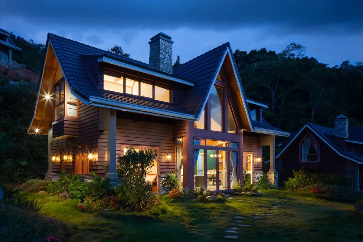 A steep-gabled home at night with a fresh tile roof